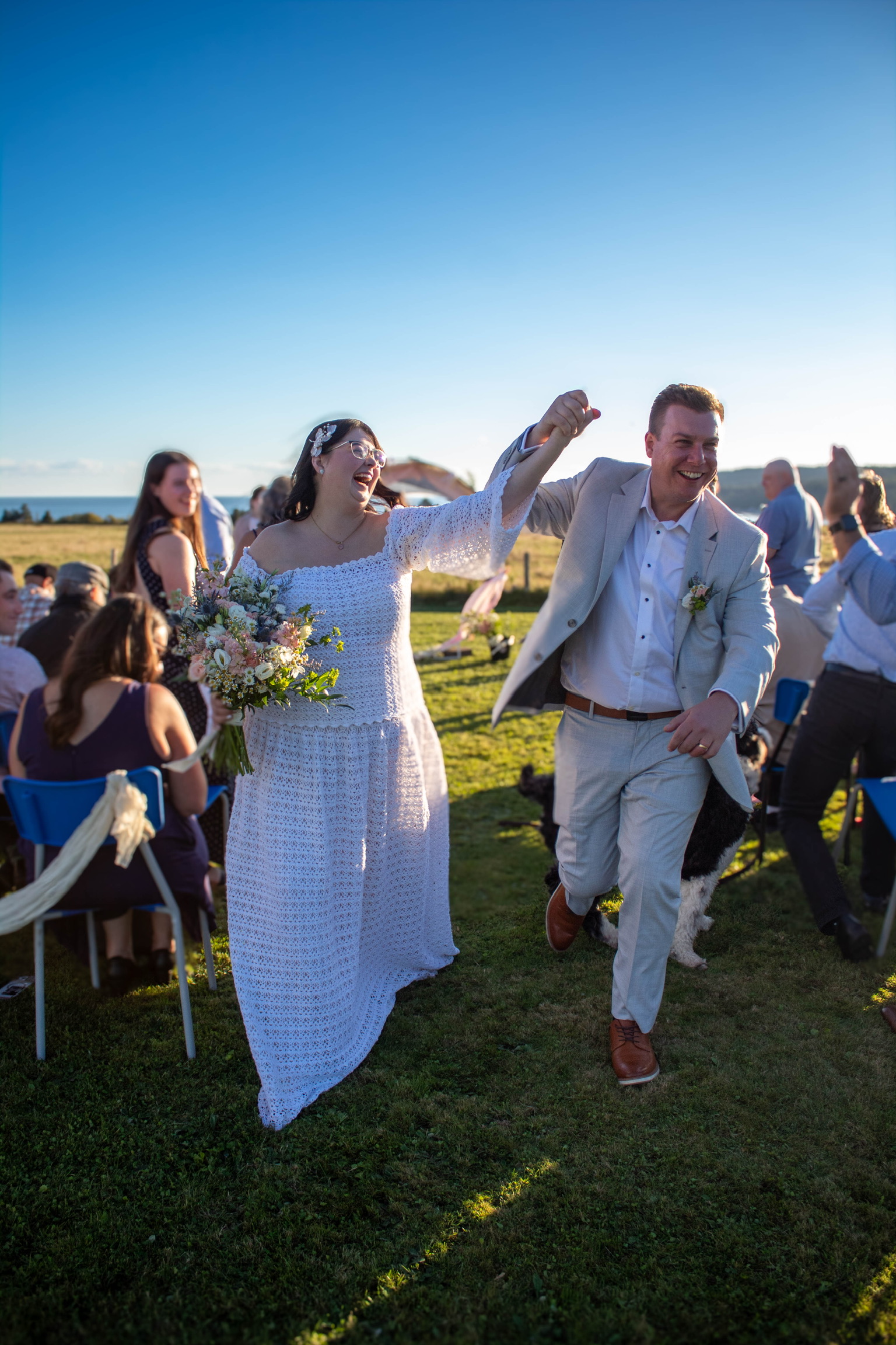 Josh and Denise walking back down the aisle, hands raised